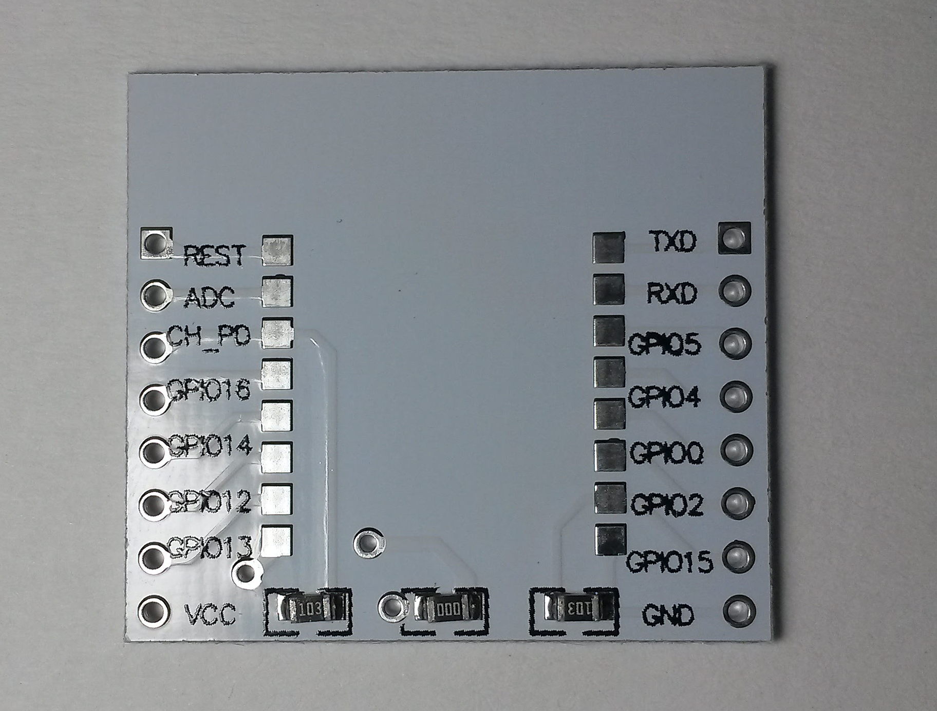 Minimal ESP-12 breakout - top side. You can see a 10k pull-up on CH_PD (enable) pin, 10k pull-down on GPIO15 and a 0R connection bridging the voltage regulator on the other side of the board.